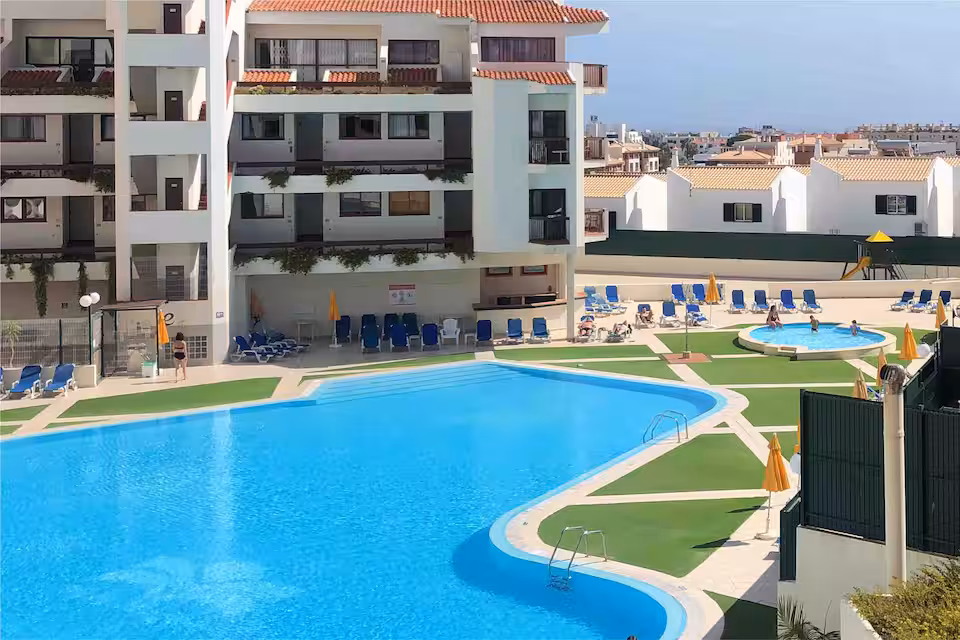 Piscinas partilhadas e edifício do condomínio Vila Magna, fotografados no anúncio do André