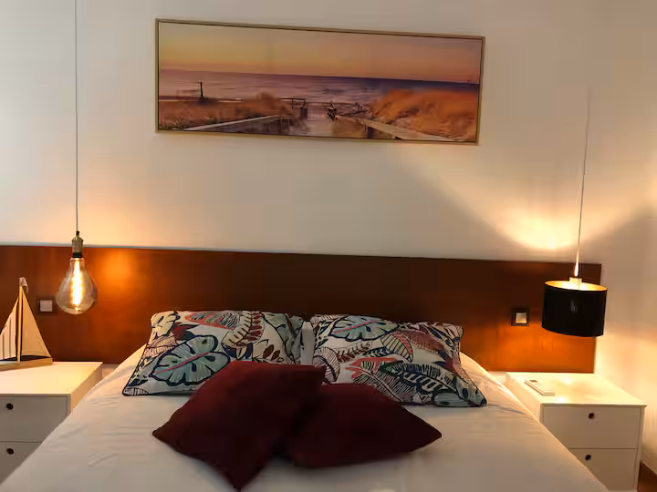 Quarto do apartamento do André, com cama de casal e cabeceira de madeira